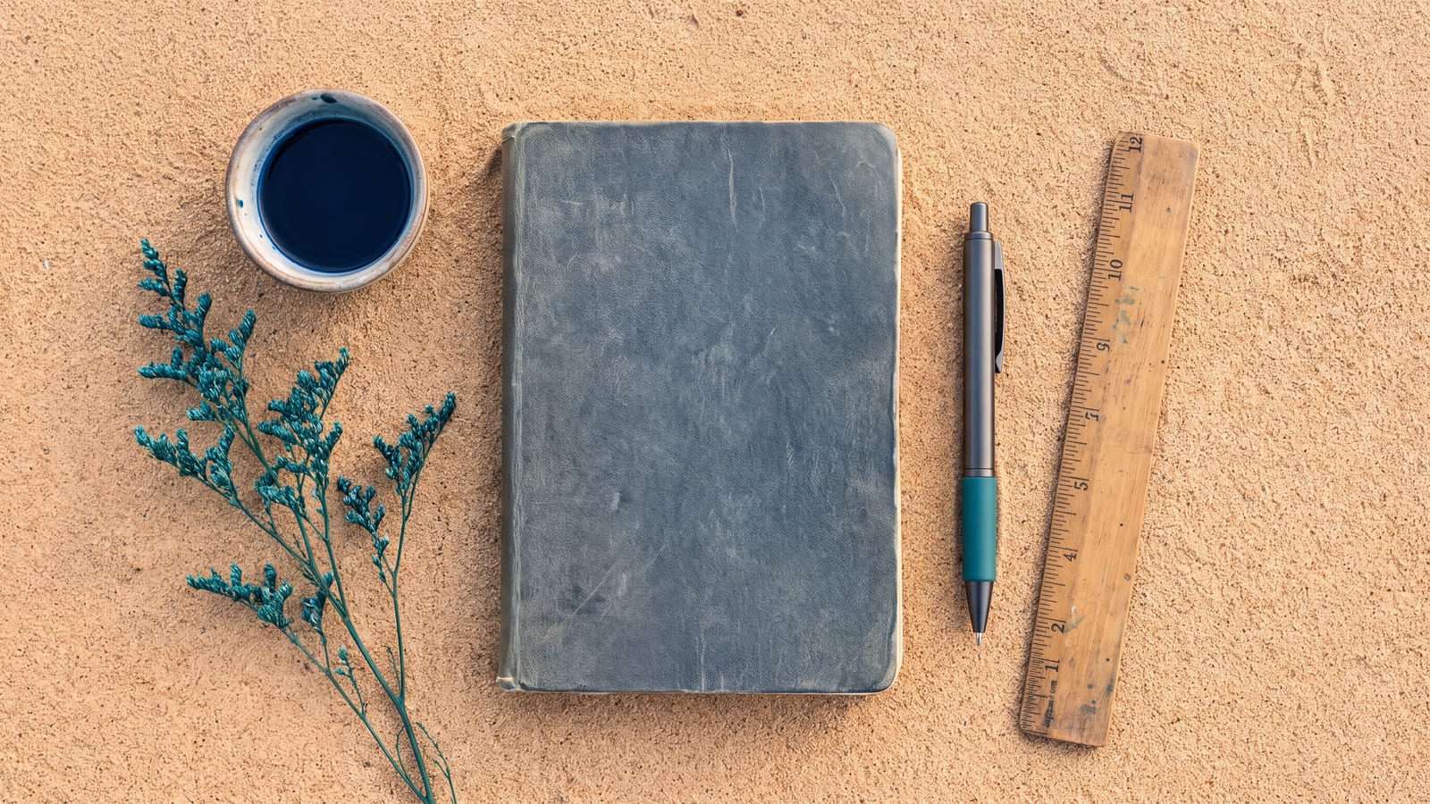 A desk with a notebook and pen in warm light