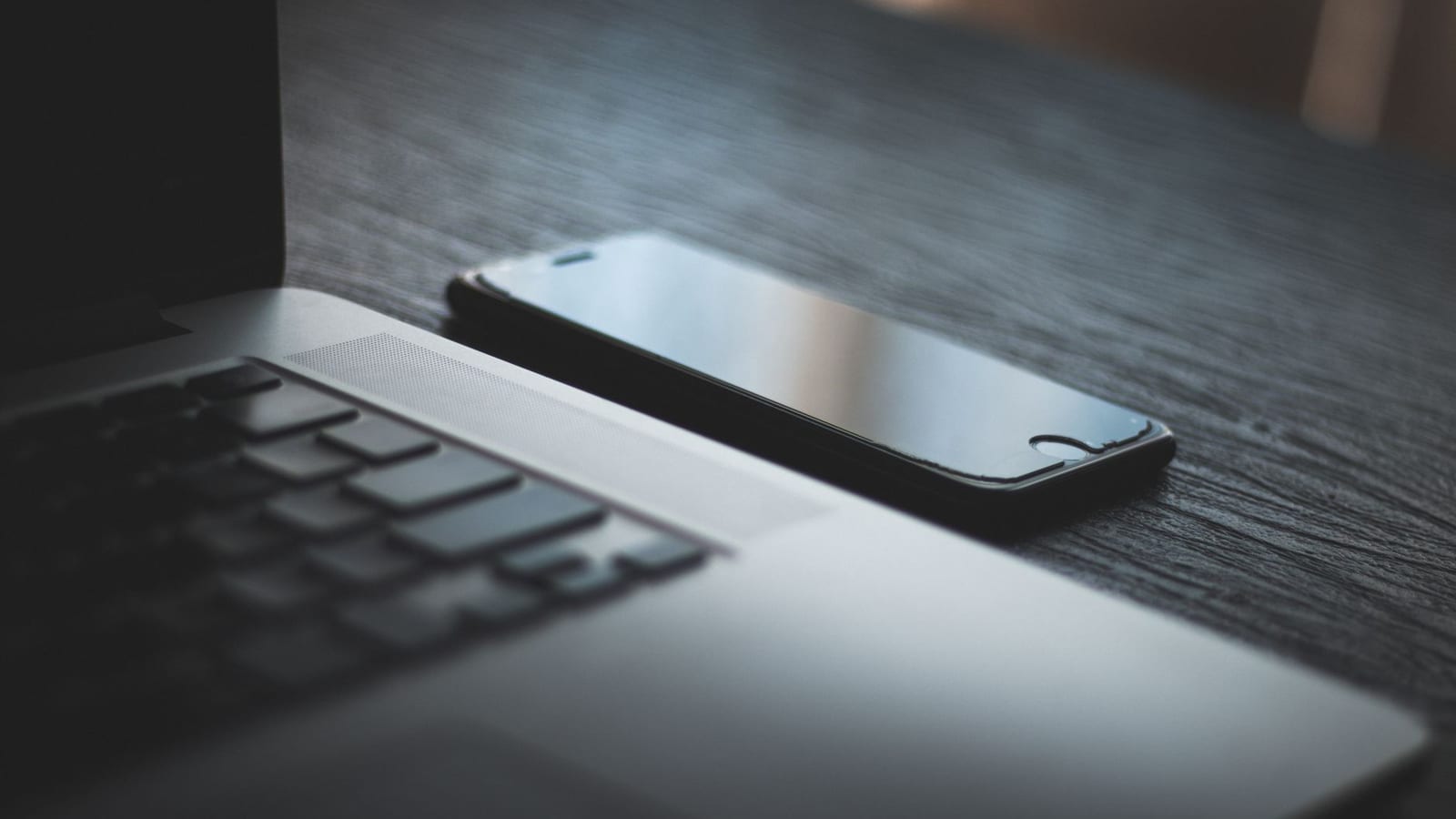A smartphone and laptop on a desk